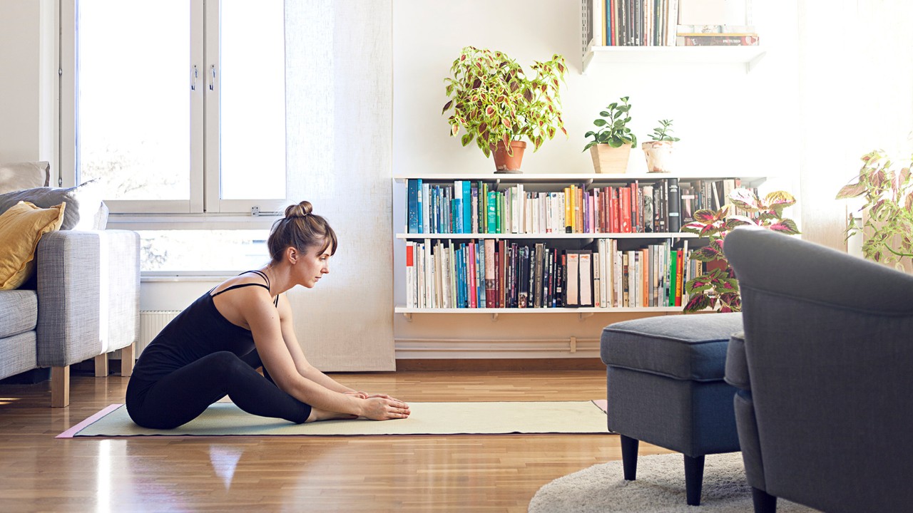 A woman is doing yoga in the living room; image used for HSBC Malaysia live within your means article page.