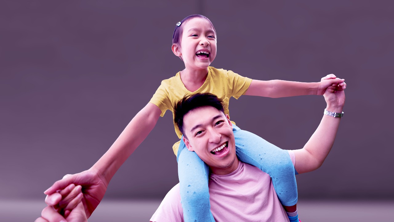 A father is giving his daughter a piggyback; image used for HSBC Malaysia Everyday Global Account page. 