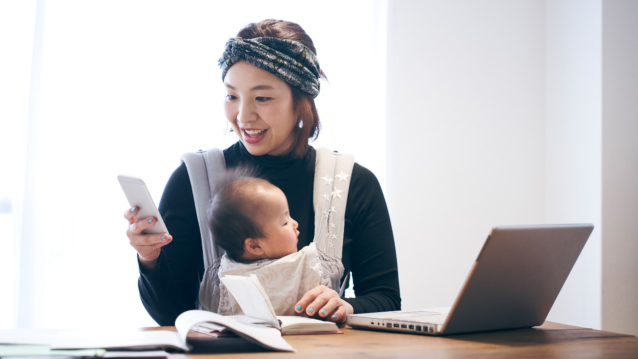 Mother with baby working at home; image used for HSBC Malaysia Remote Engagement Service page.