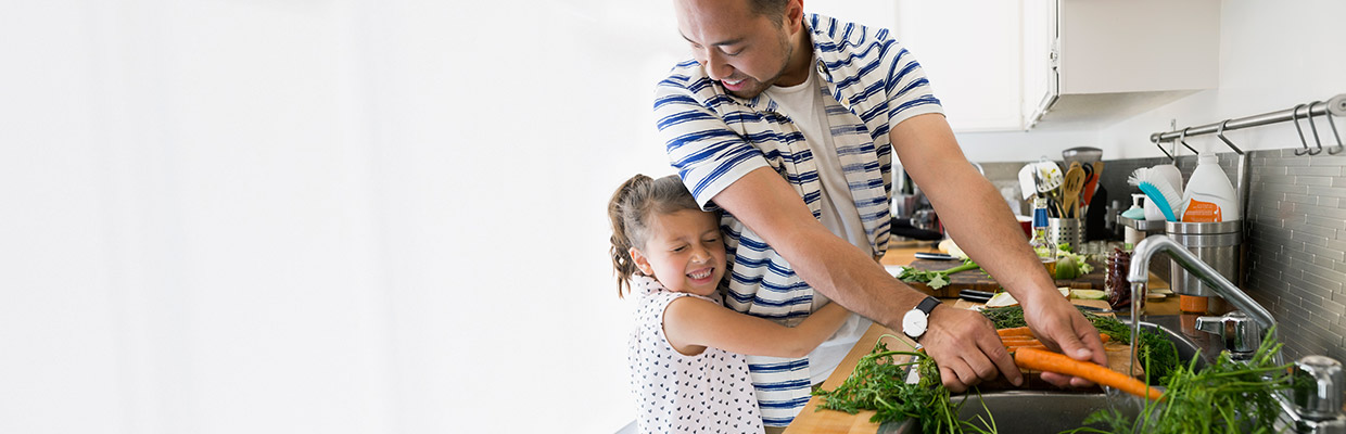 A father and daughter are cooking together; image used for HSBC Malaysia Protection