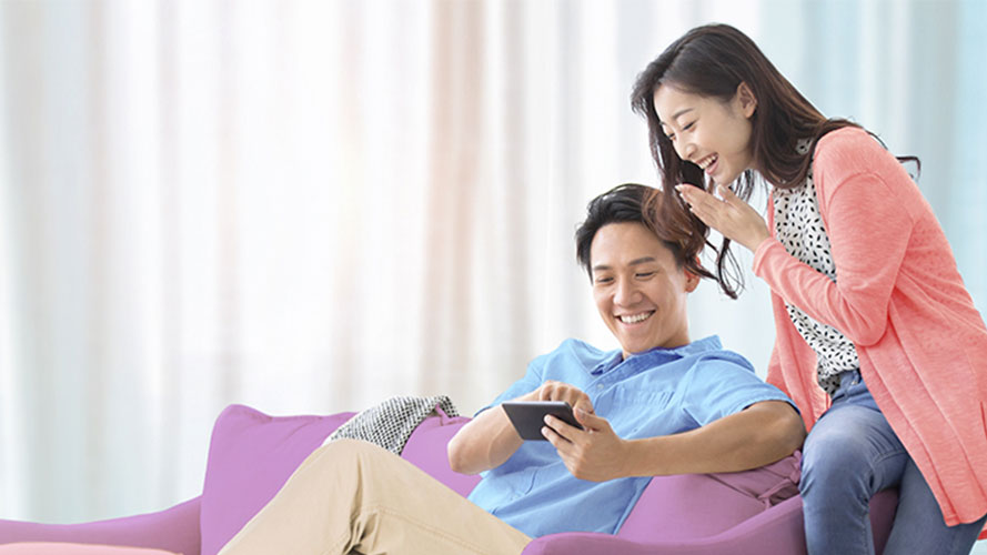 Happy couple is using mobile; image used for HSBC Malaysia Balance Conversion Plan page.