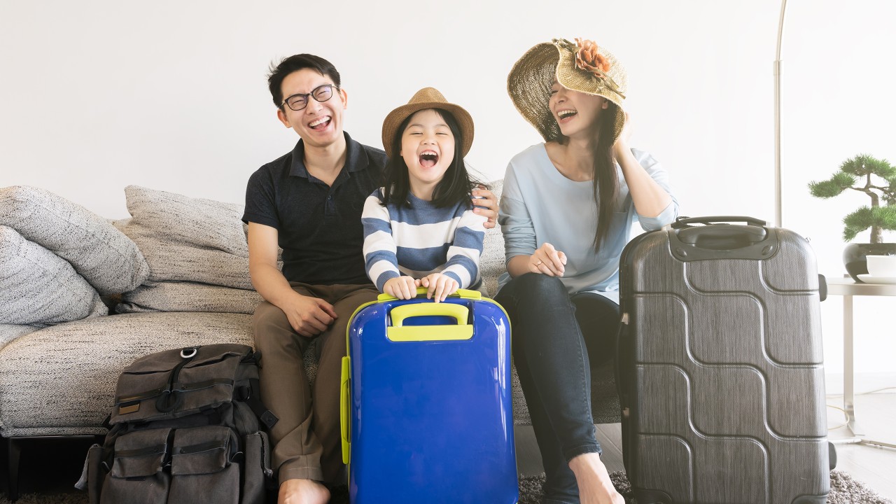 A Family smiling at home happy; image used on HSBC Malaysia Premier Travel Credit Card page. 