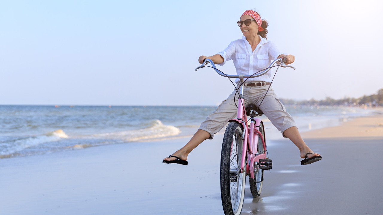 Woman riding bike; image used for HSBC's UniversalTreasure Plus Plan page.