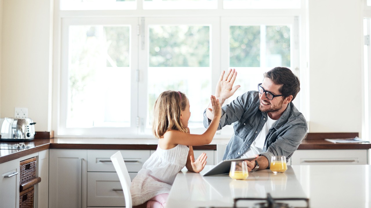 Father and daughter having breakfast and giving a high five.  Image used for HSBC Malaysia Apply for a Malaysia credit card page.