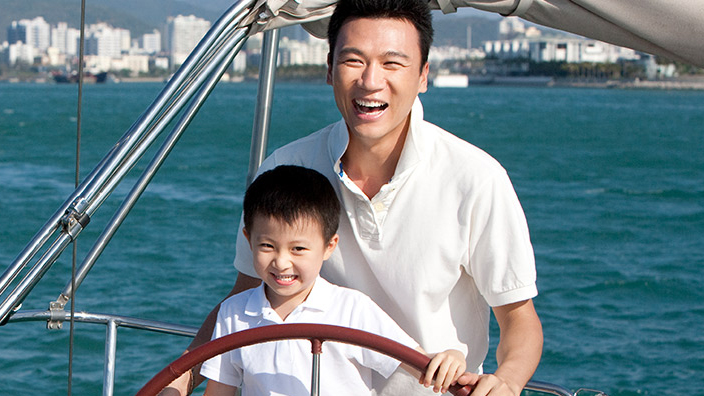 A father is sailing a boat with his son; image used for HSBC Malaysia Structured Investment page