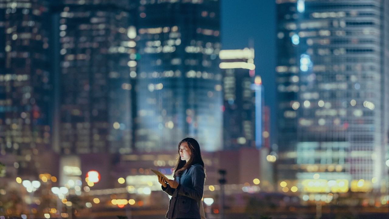 A woman is using a tablet at night; image used for HSBC Malaysia Dual Currency Investment page.