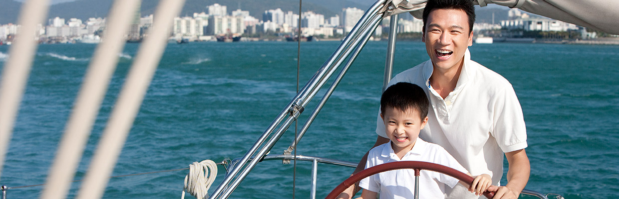 A father is sailing a boat with his son; image used for HSBC Malaysia Structured Investments