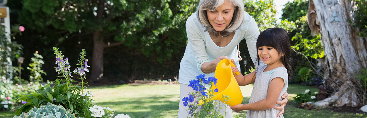 A grandmother and granddaughter are watering flowers; image used for HSBC Malaysia Second Home Mortgage