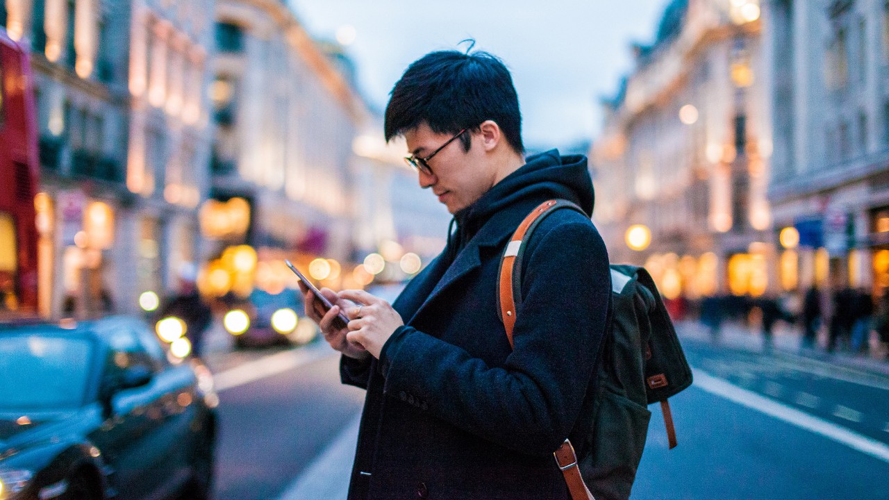 A man is looking at his phone; image used for HSBC Malaysia online banking